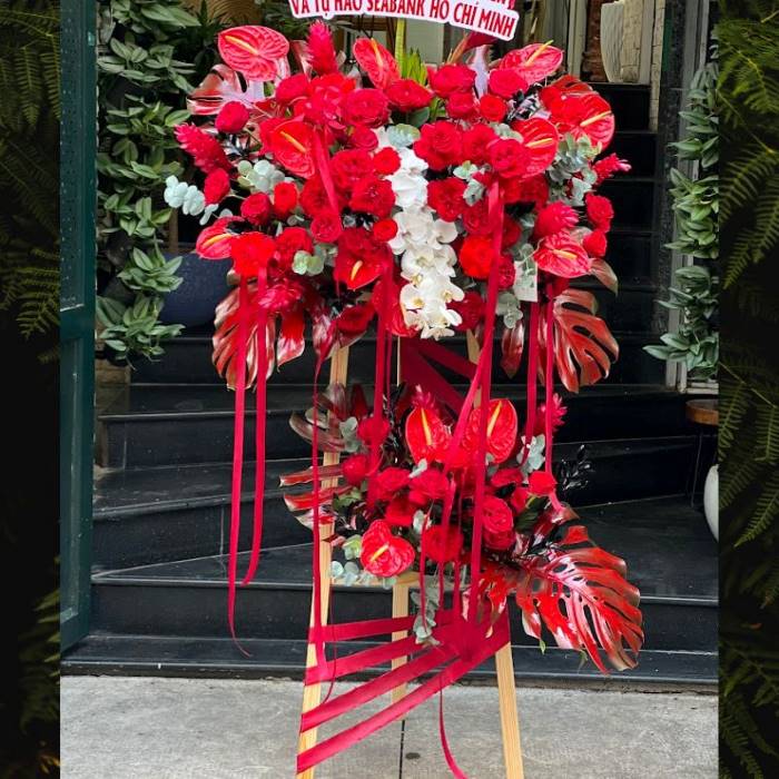 Hoa hồng môn đỏ rực tạo điểm nhấn nổi bật cho kệ hoa mừng khai trương cửa hàng spa